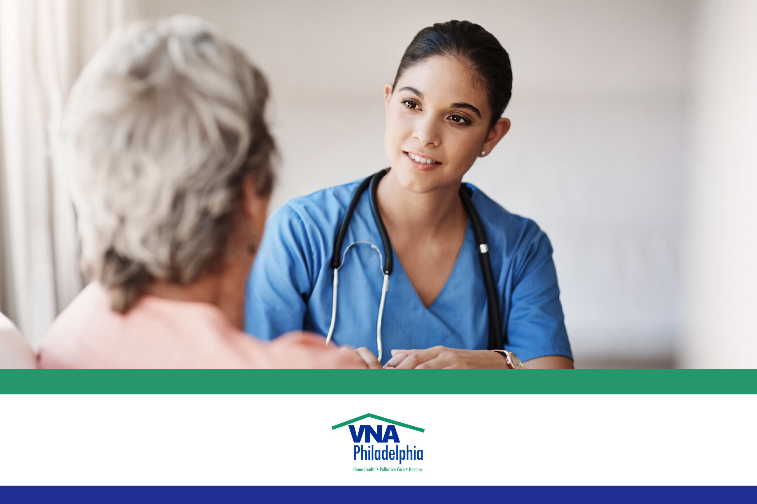 A young woman with brown hair, wearing light blue scrubs and a stethoscope, nods and smiles