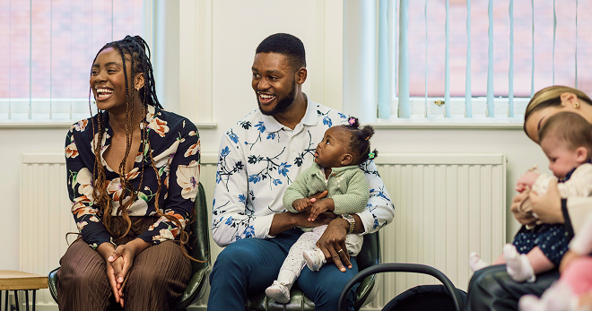 Parents sitting with their young children in a parenting class.