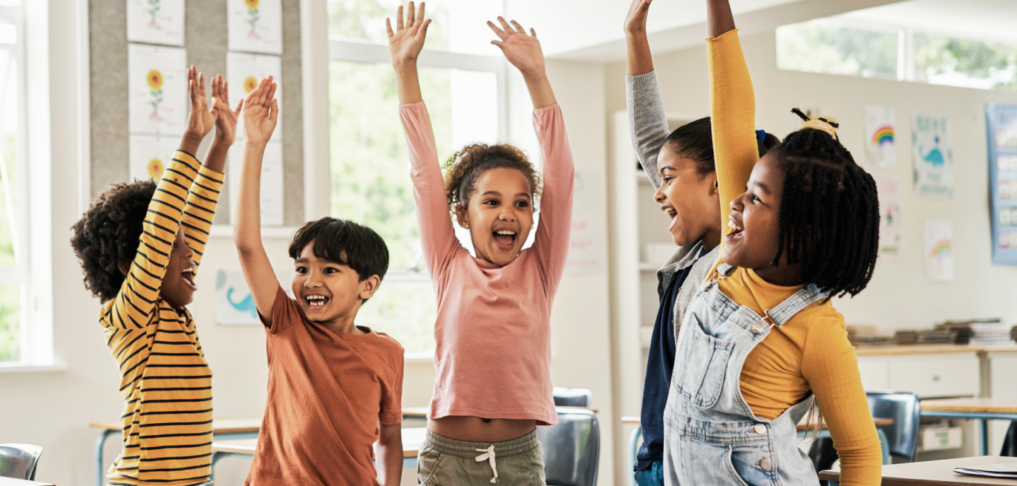 Students standing up and raising their hands during class.