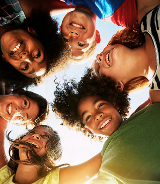Group of children smiling in a circle.