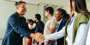 Professionals greeting one another at a conference.