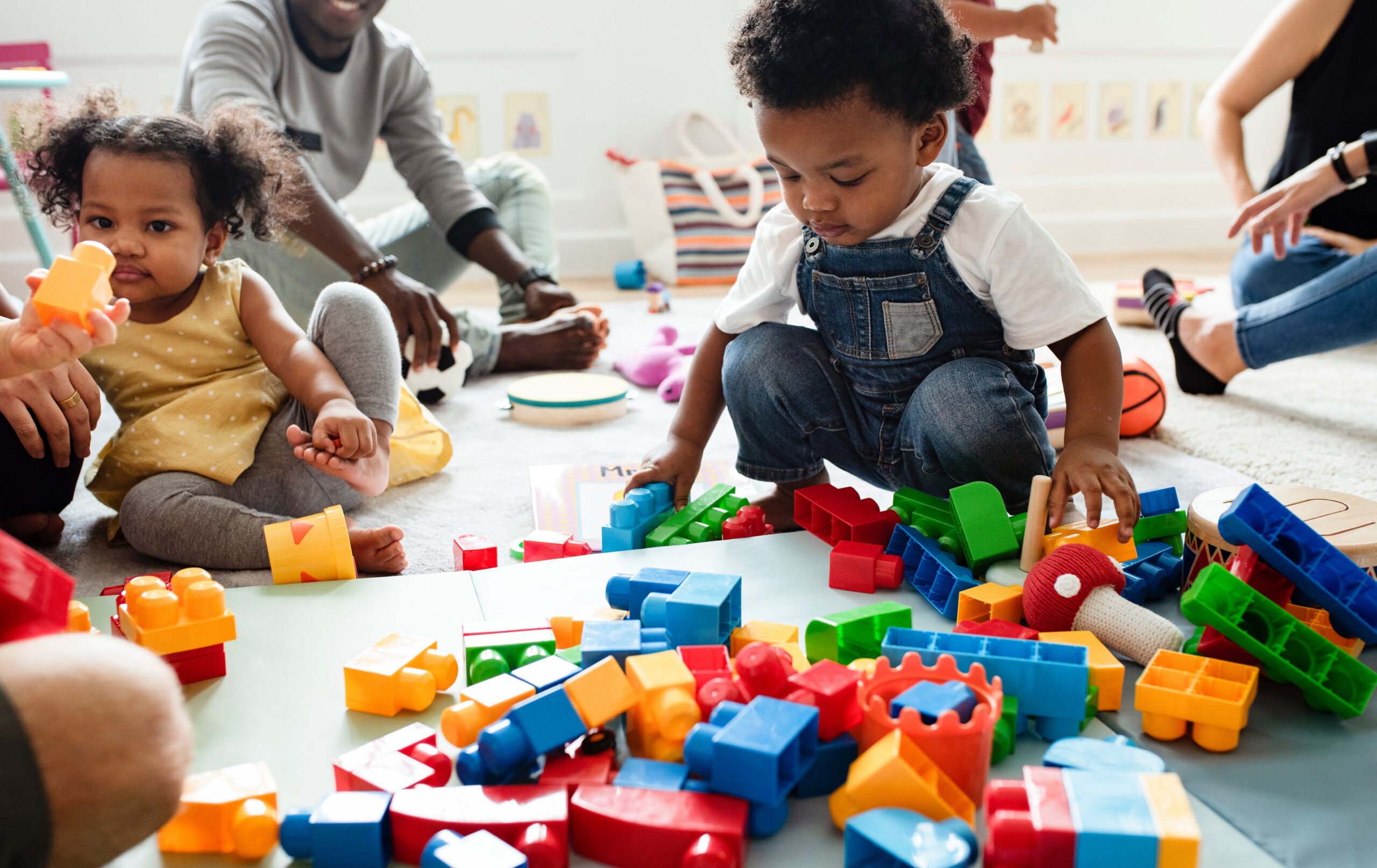 Diverse young children enjoying playing with blocks in a bright play room